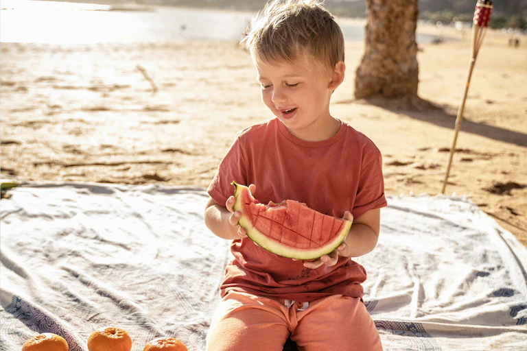 Un enfant mange des fruits.