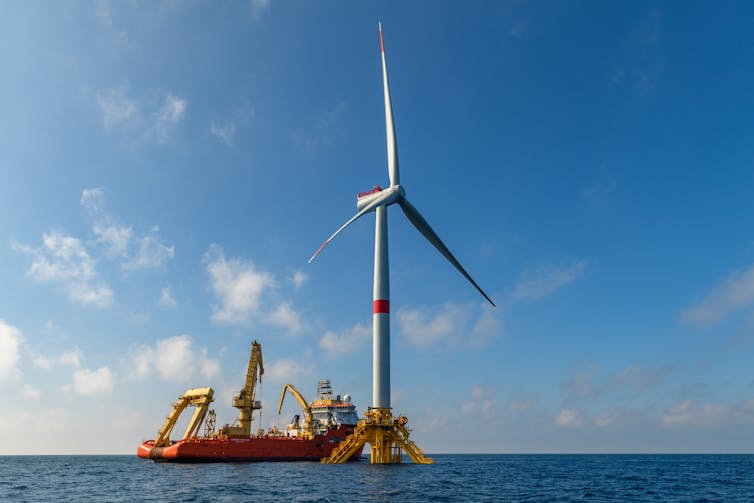 ship installing a wind turbine in ocean.