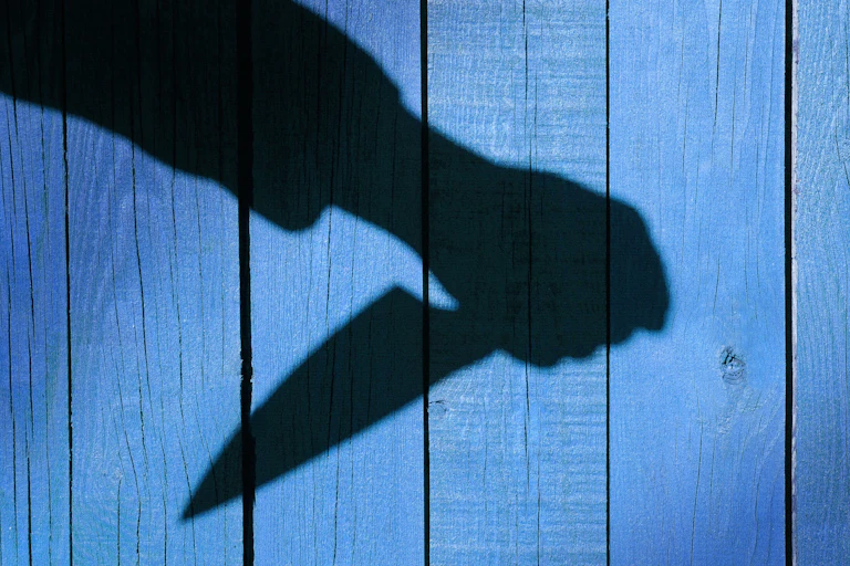 A shadowed knife is seen on a blue background