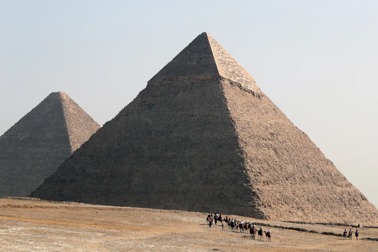Tourists ride on camels as they visit the Giza Plateau, home of the Great Pyramids of Giza, in Giza, Egypt.