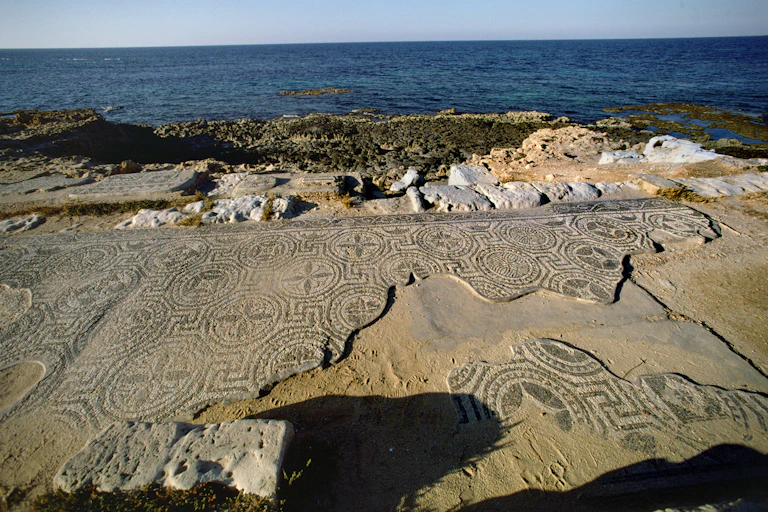 Crumbling mosaic tiles and ruins next to the sea