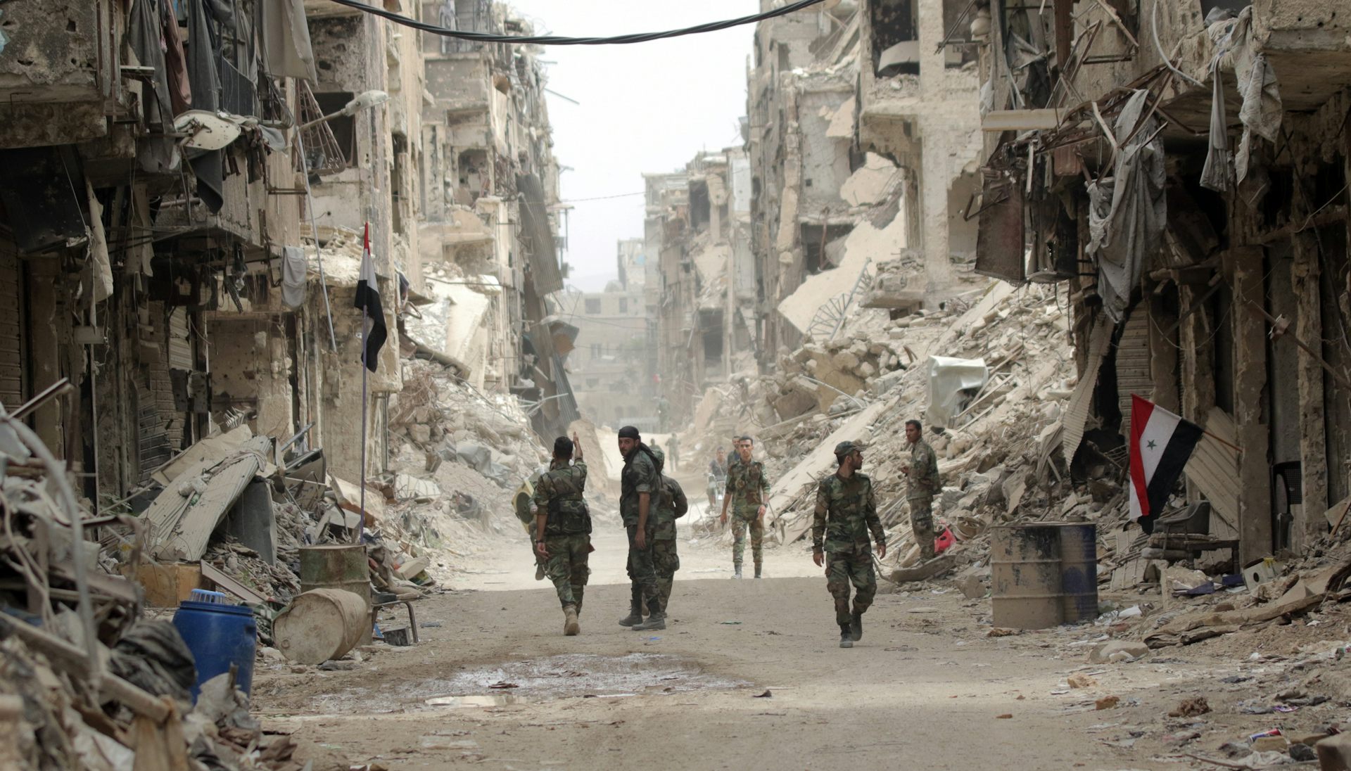 Syrian soldiers patrol a war-damaged neighbourhood of Damascus.
