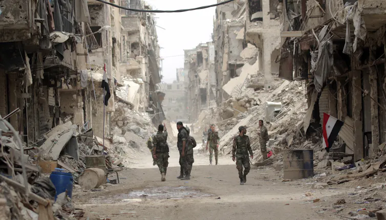 Syrian soldiers patrol a war-damaged neighbourhood of Damascus.