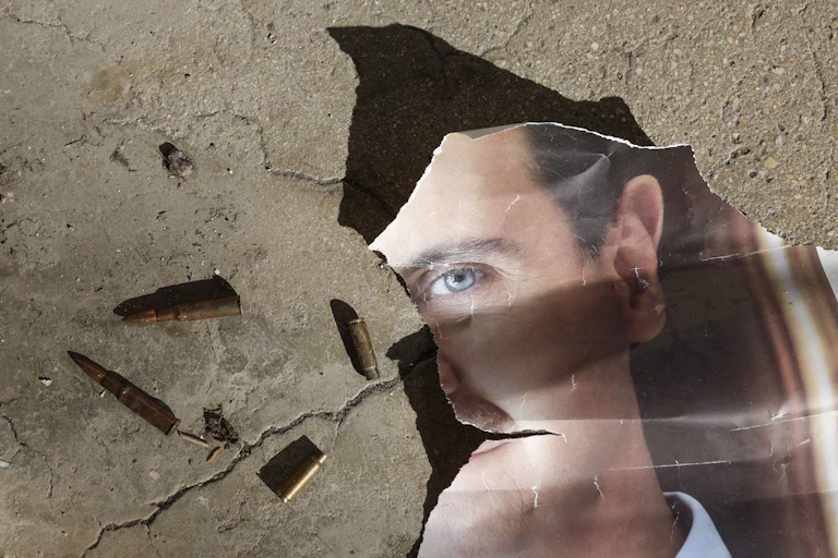 A torn portrait of Syria's former president, Bashar al-Assad, on the ground.