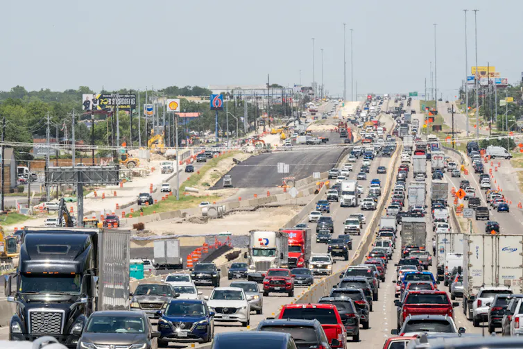 A multilane highway is packed with cars and trucks.