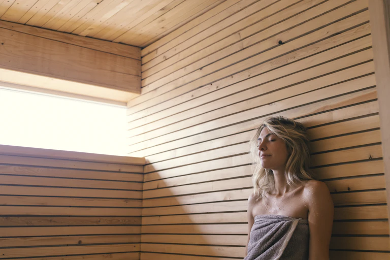 A woman sitting in a sauna.