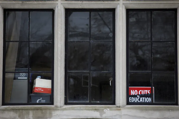 A no cuts to education sign seen in a school window.