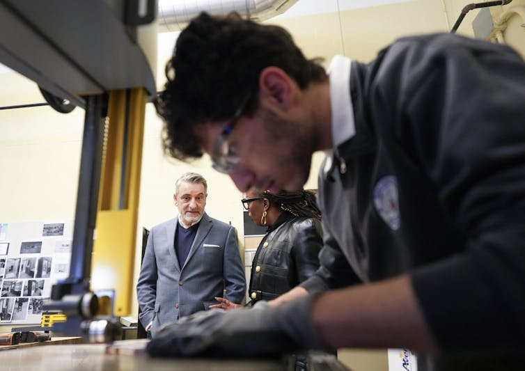 Estudiante en el trabajo hasta que dos adultos miran el fondo.