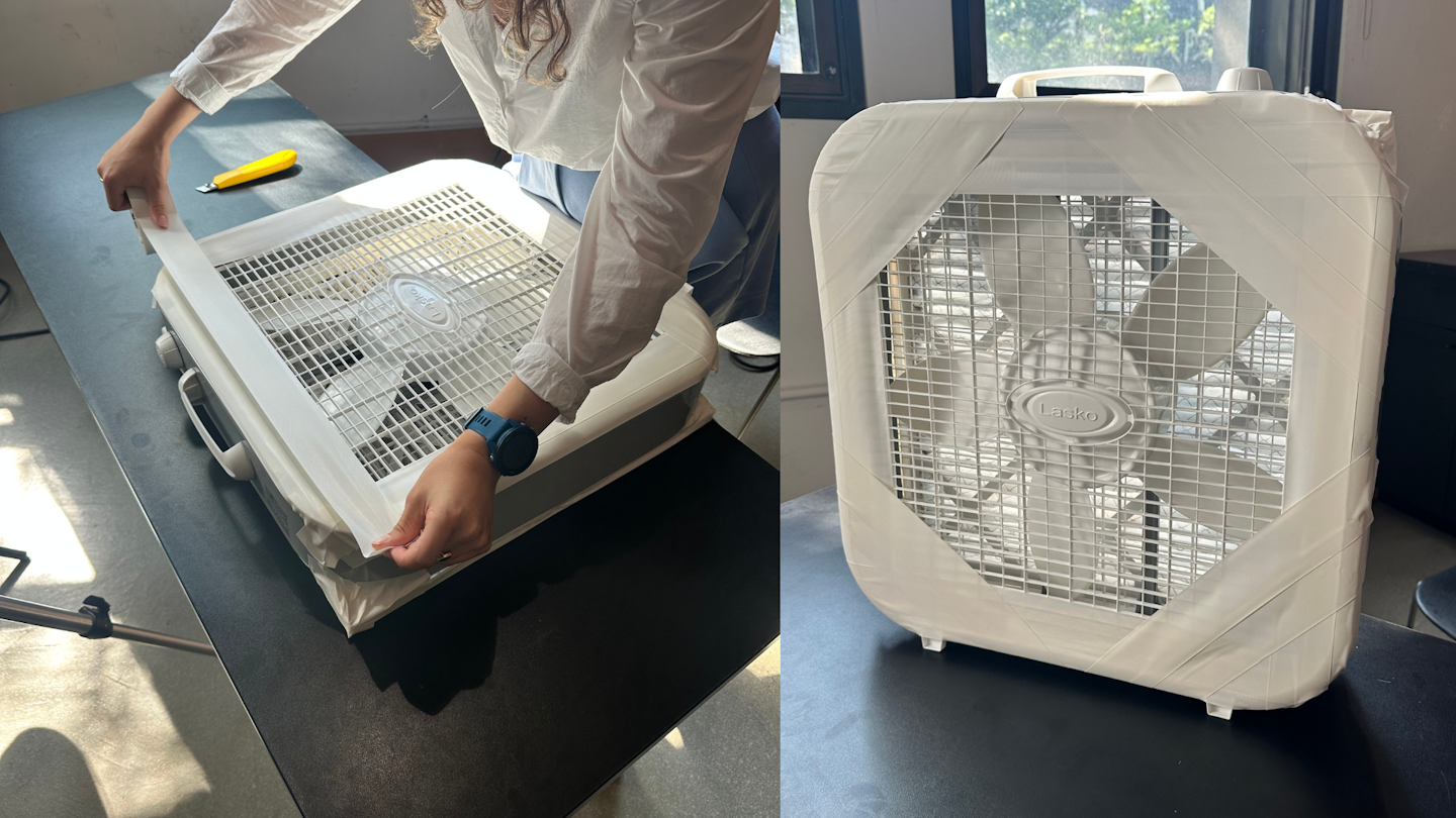 fan blades inside a box with holes for air to pass through held together using duct tape.