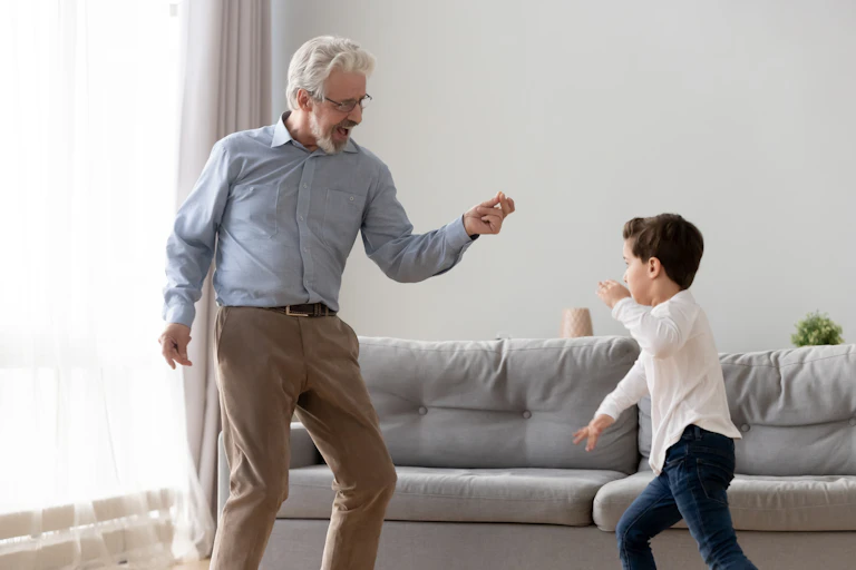 Older man and little boy dancing together