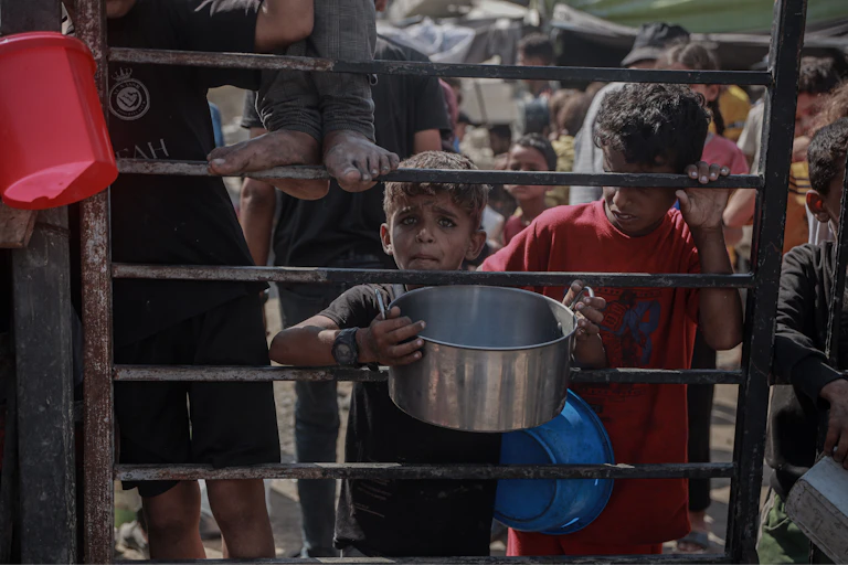 Crowds form as Palestinians wait for food distributed by a charity amid the ongoing Israeli blockade and attacks on Gaza.