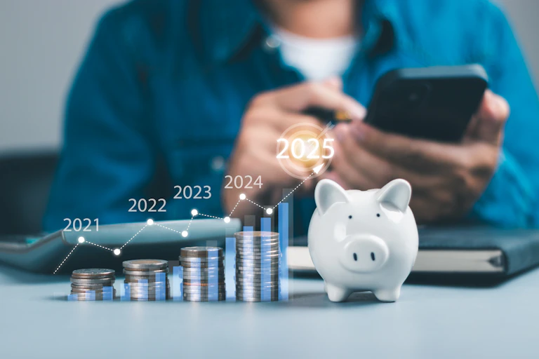 Closeup of stacked coin growth chart 2025. Man calculating financial planning.