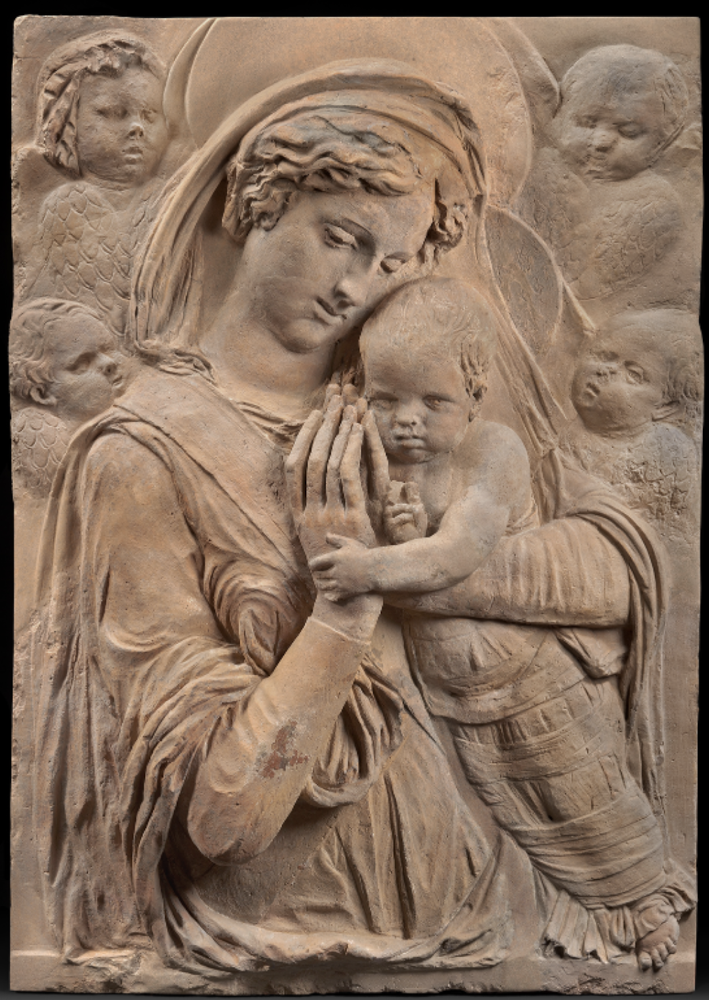 A relief carving featuring Mary, Jesus, and four cherubs.
