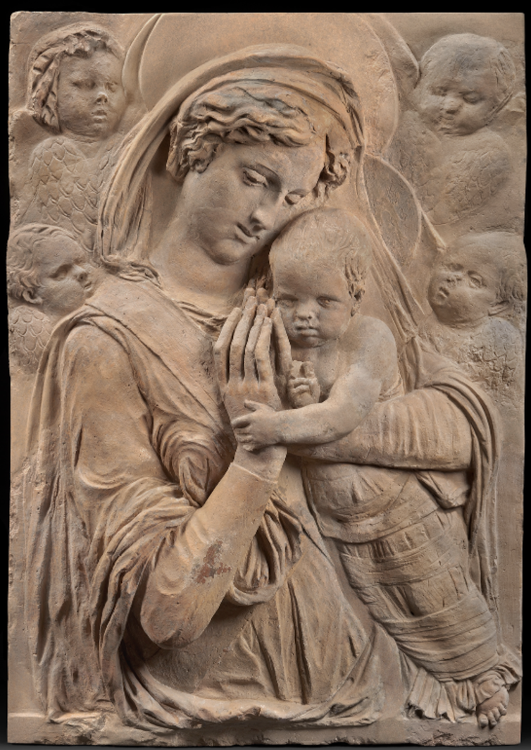 A relief carving featuring Mary, Jesus, and four cherubs.