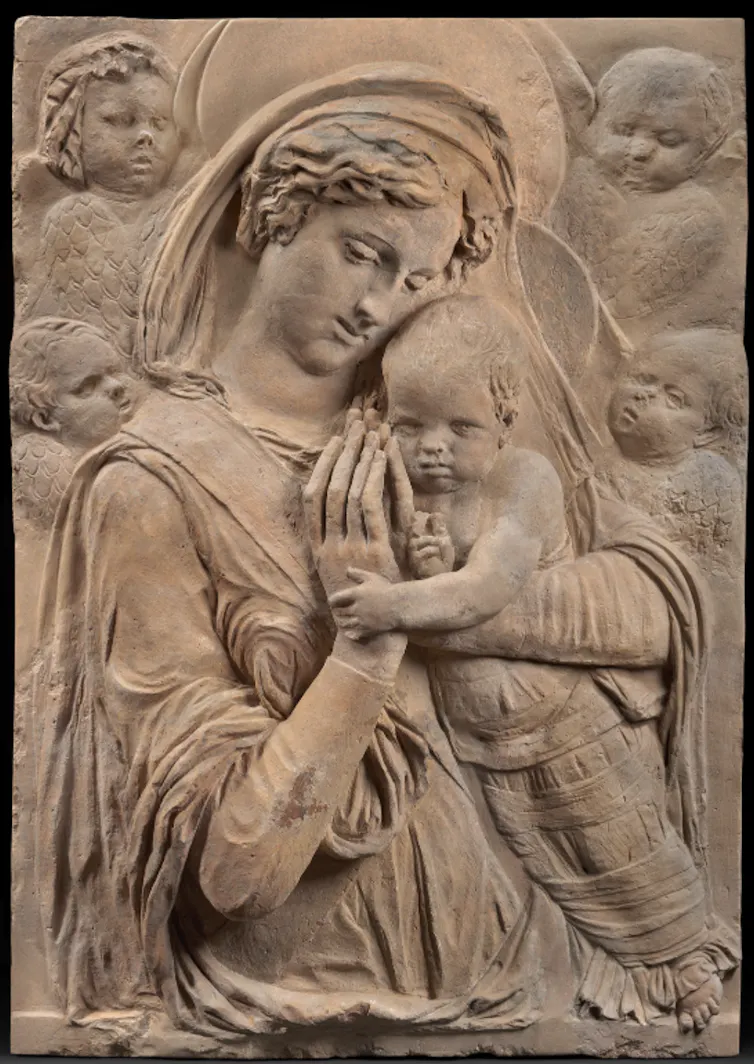 A relief carving featuring Mary, Jesus, and four cherubs.
