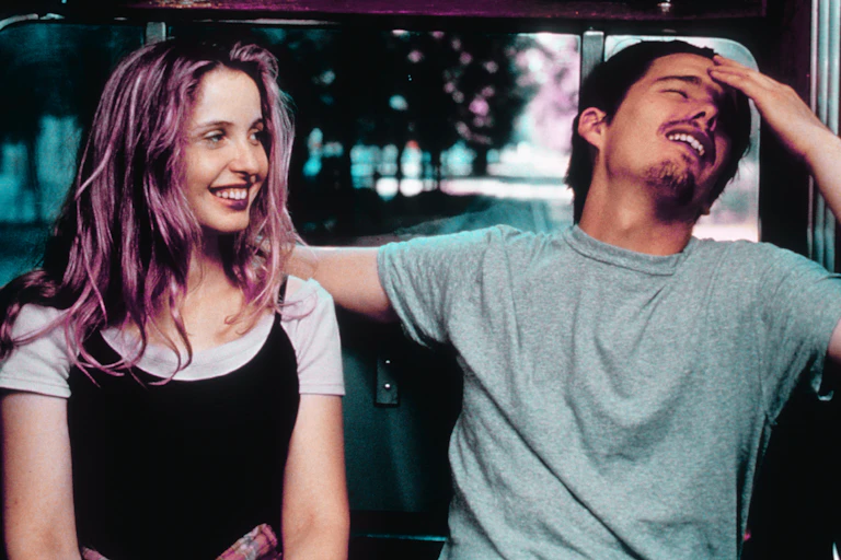 Una pareja de jóvenes habla en un autobús