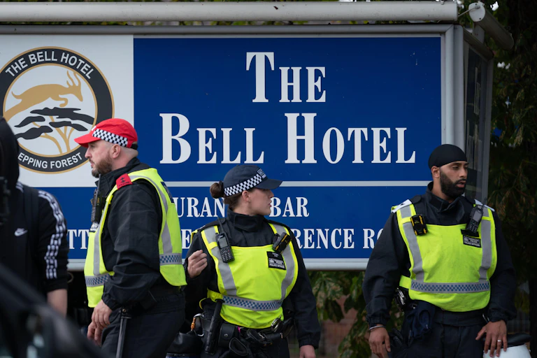 Police in front of a sign at the Bell Hotel