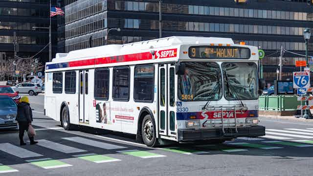Public bus drives down a commercial corridor