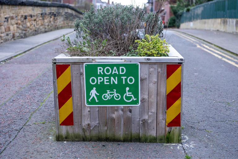 green road sign, road open to pedestrians, cyclists, wheelchair users, quiet road behind