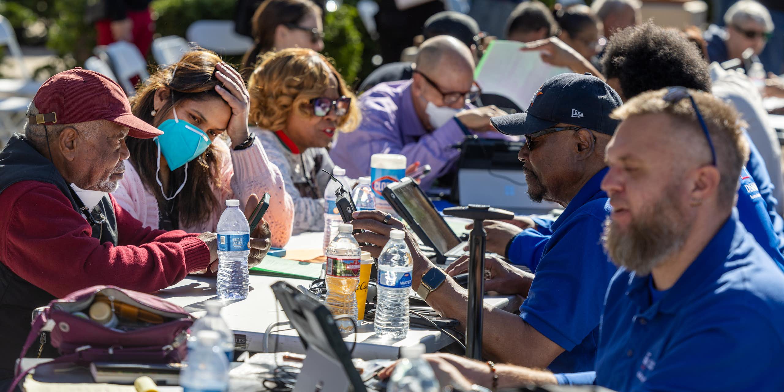 People who lost homes and businesses to the Los Angeles wildfires get help filling out forms from staff at a FEMA assistance center.