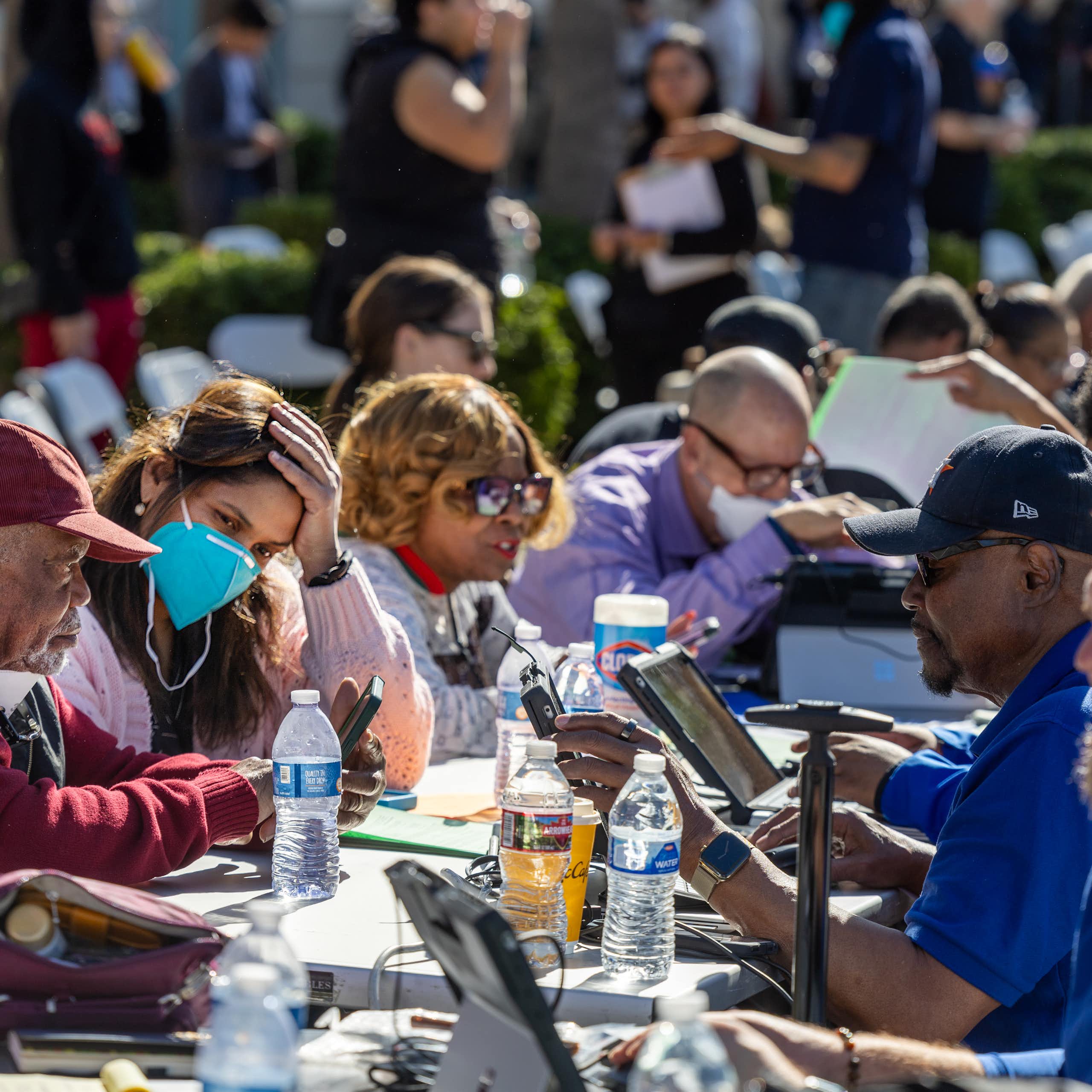 People who lost homes and businesses to the Los Angeles wildfires get help filling out forms from staff at a FEMA assistance center.