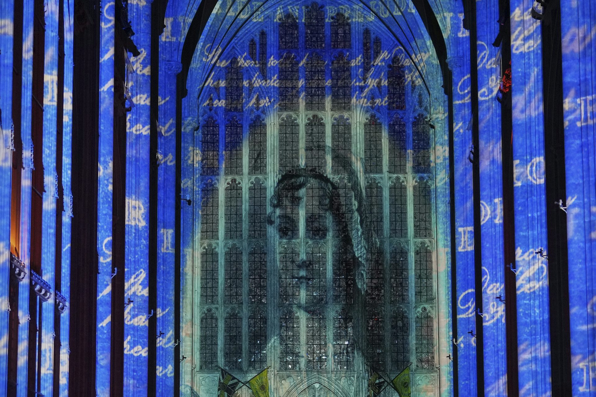 A projected image of a woman seen on church windows.