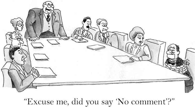 A cartoon of a group of people round a board table with one person gagged and bound. The leader of the meeting is asking,