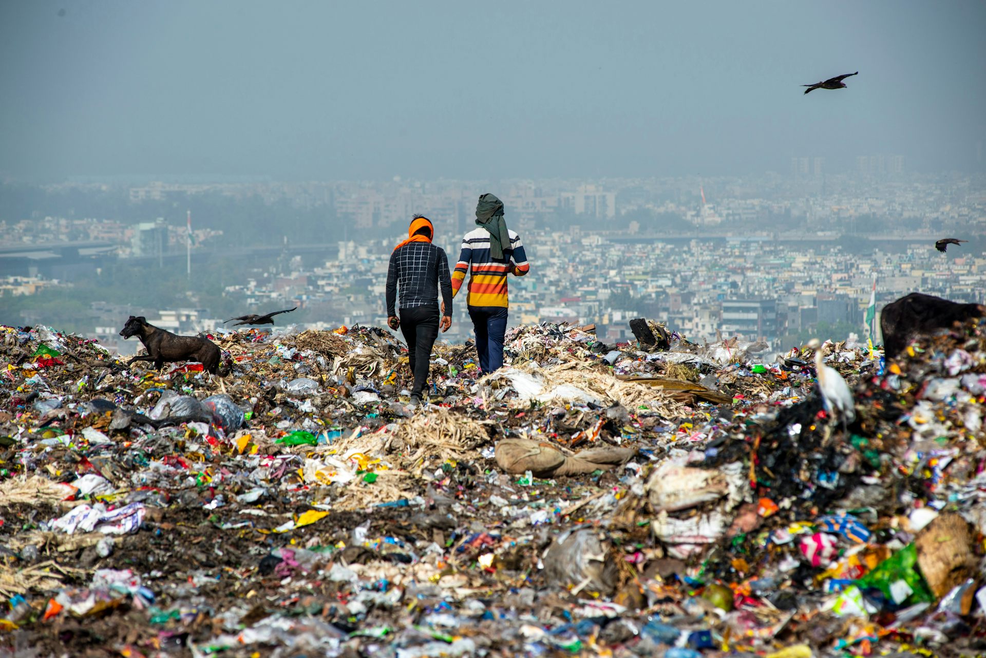 two people stood on landfill overlooking city