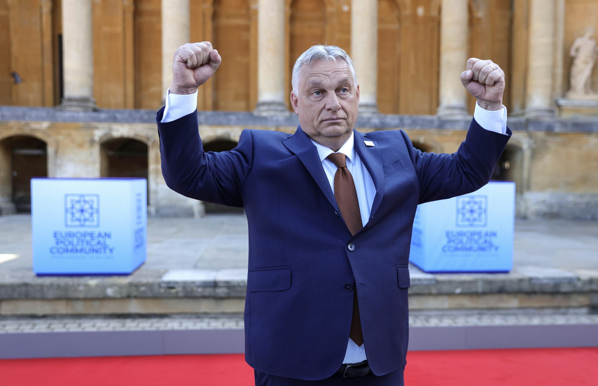 Vikto Orban striking a pose like a body builder.