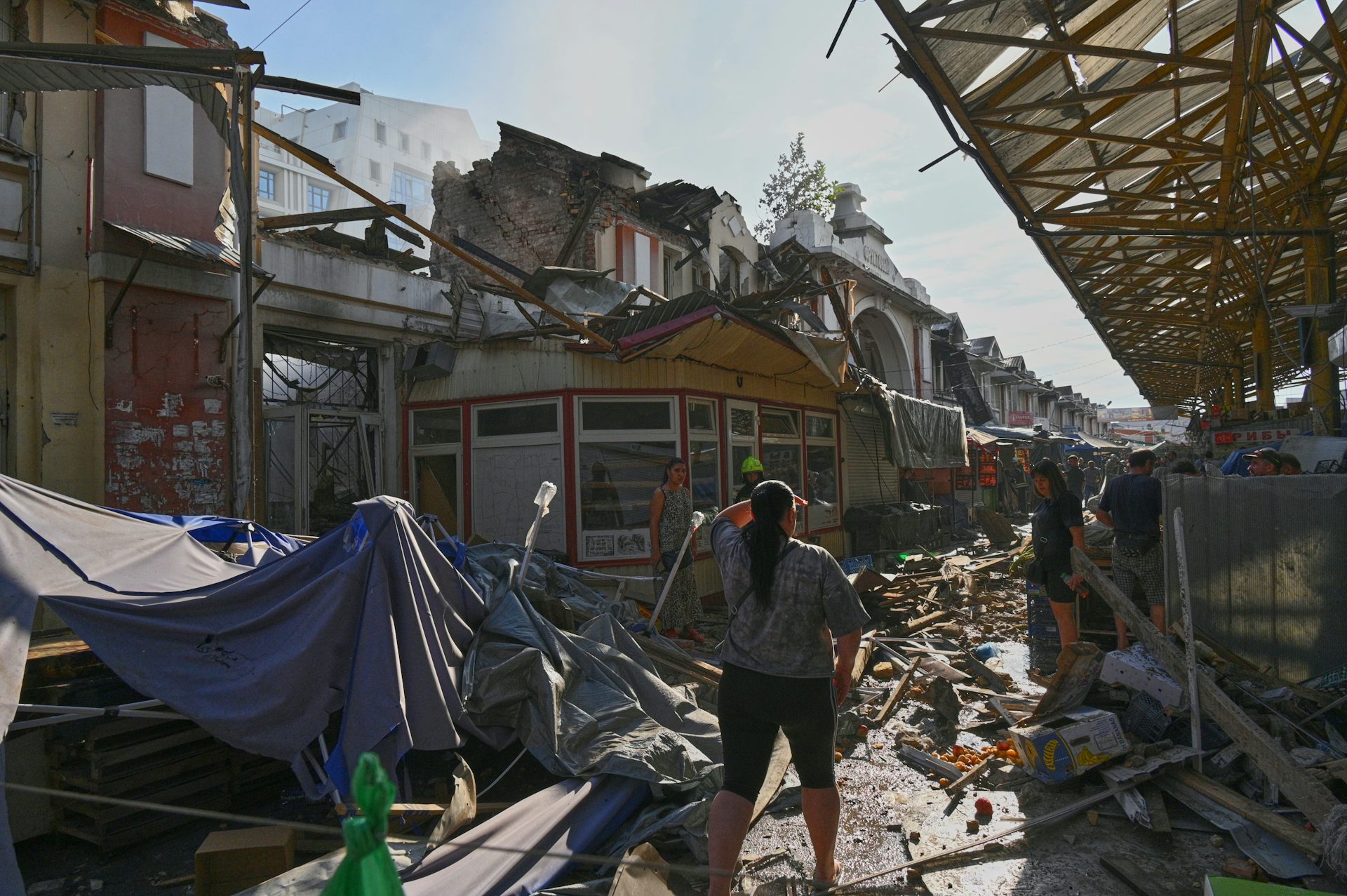 Des citoyens parmi des décombres.