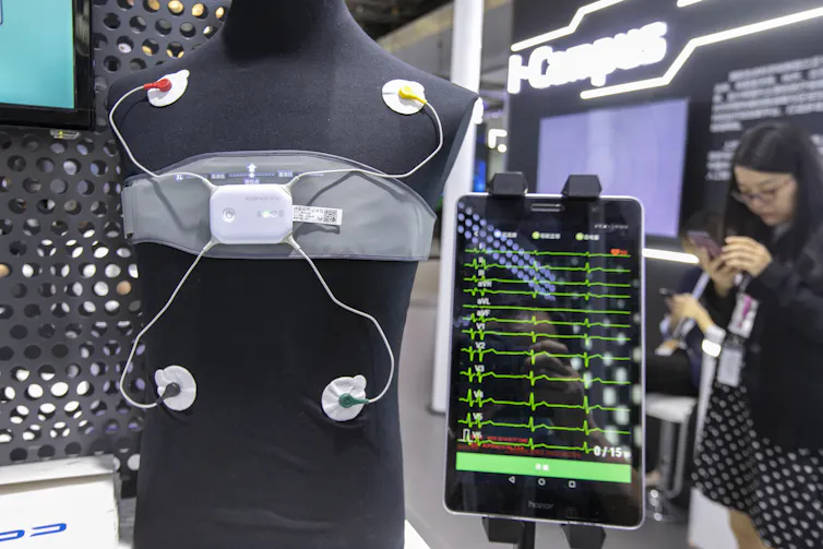 a mannequin wearing a device across the chest with four wires attached to circular pads attached to the torso