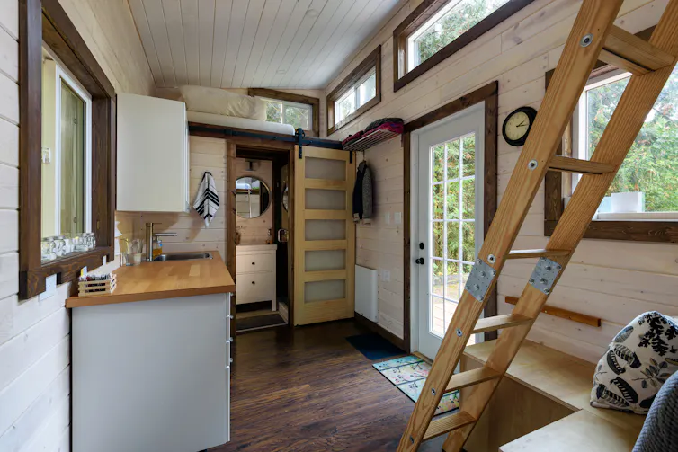 Interior design of a dining room and kitchen in a tiny rustic log cabin.