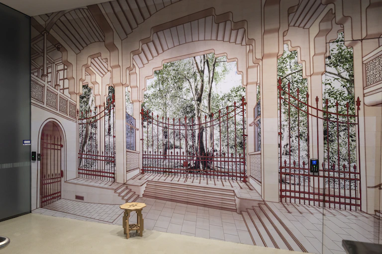 A large mural of a fence, with trees behind.