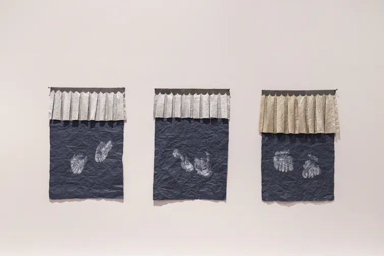 Three rubbings of statues' feet.