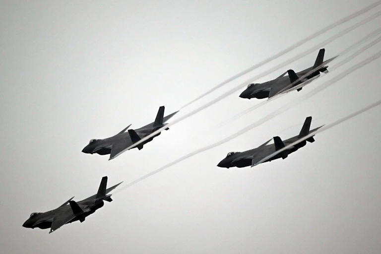 Four stealth fighter jets in the air.