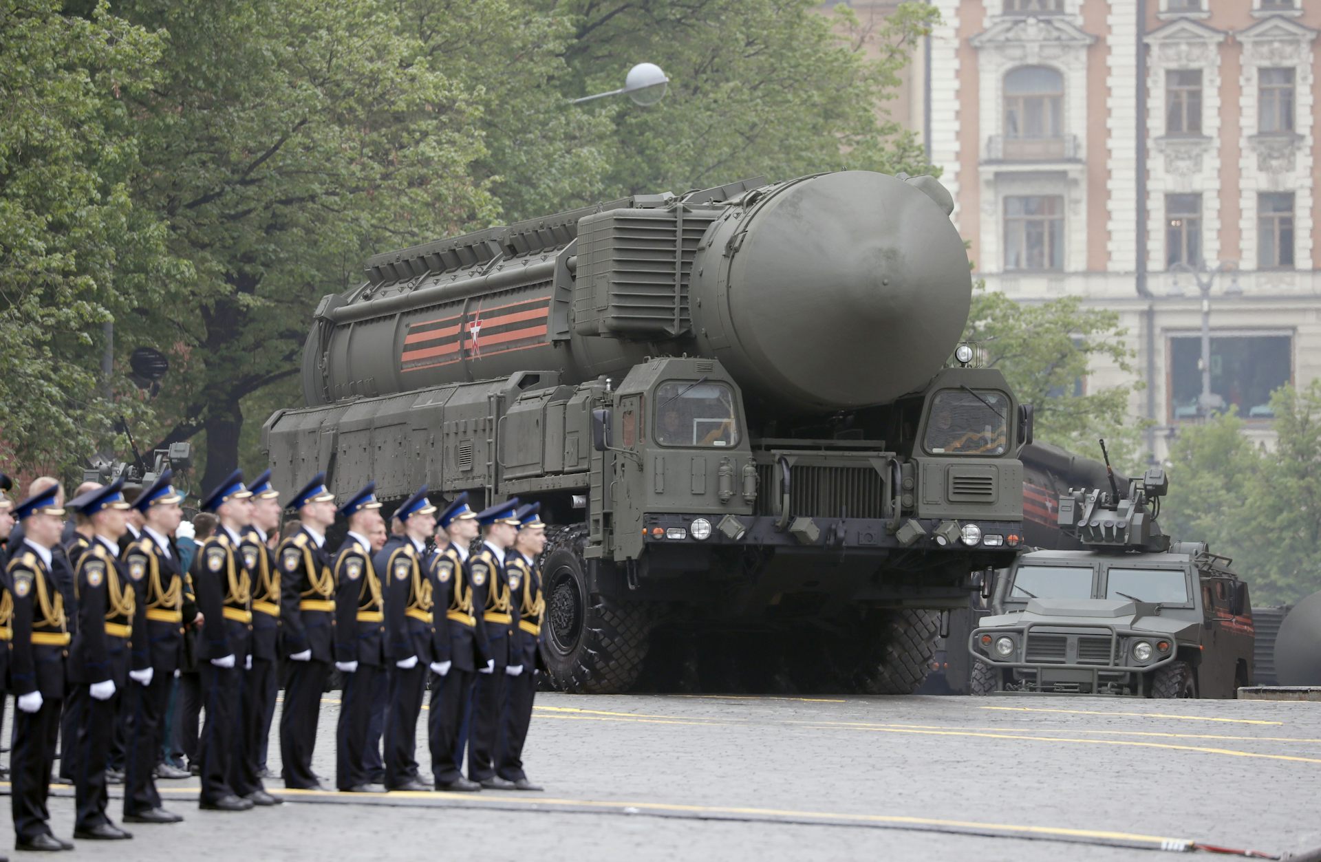 A bregade of Russian soldiers stands to attention as a truck with a nuclear missiles drives past.