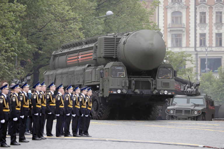 A bregade of Russian soldiers stands to attention as a truck with a nuclear missiles drives past.