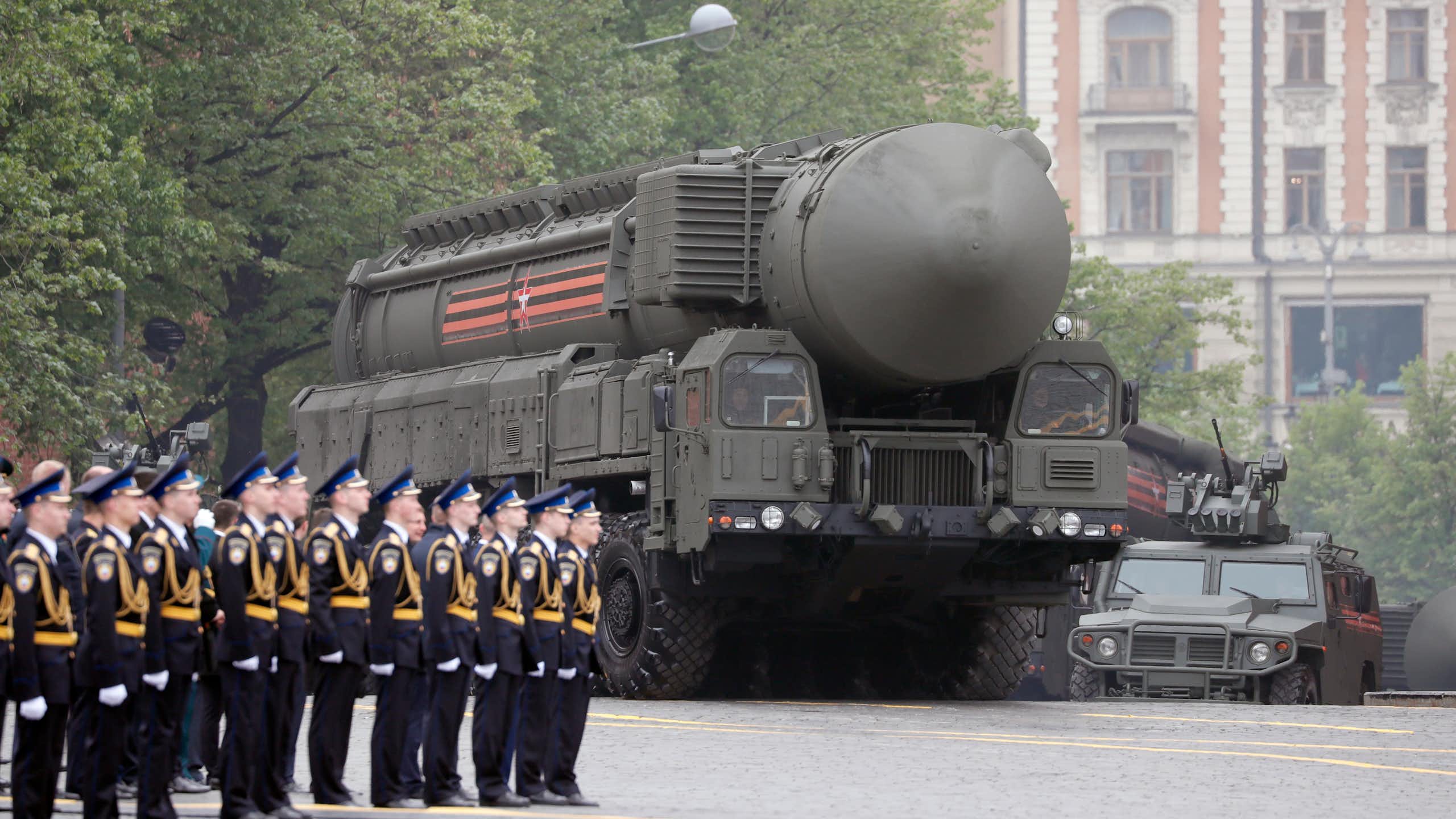 A bregade of Russian soldiers stands to attention as a truck with a nuclear missiles drives past.