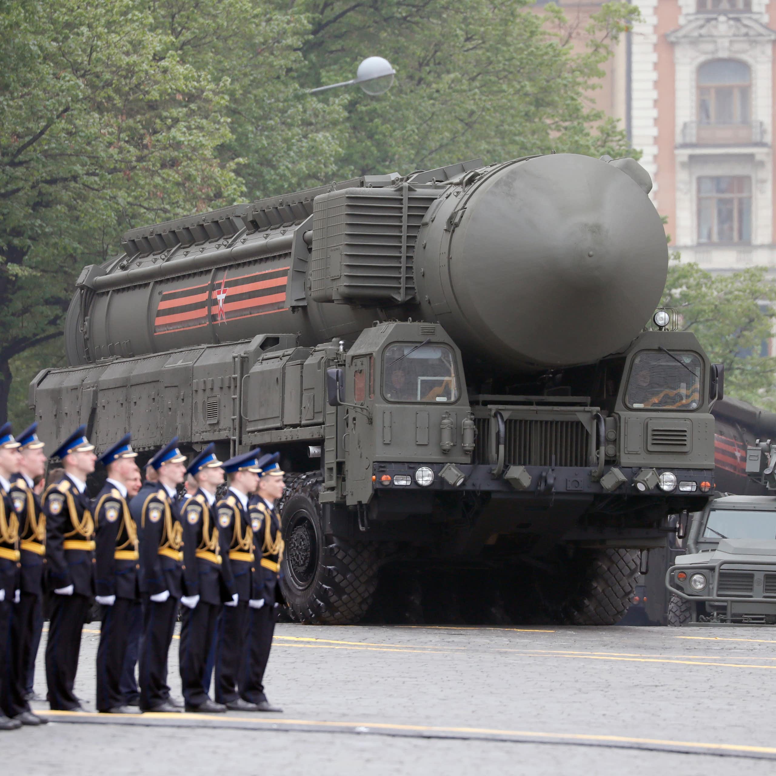 A bregade of Russian soldiers stands to attention as a truck with a nuclear missiles drives past.