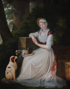 Pintura de una mujer sentada con un niño pequeño y un perro a los pies.