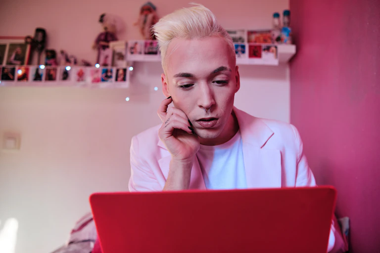 A nonbinary person looks at a computer screen.