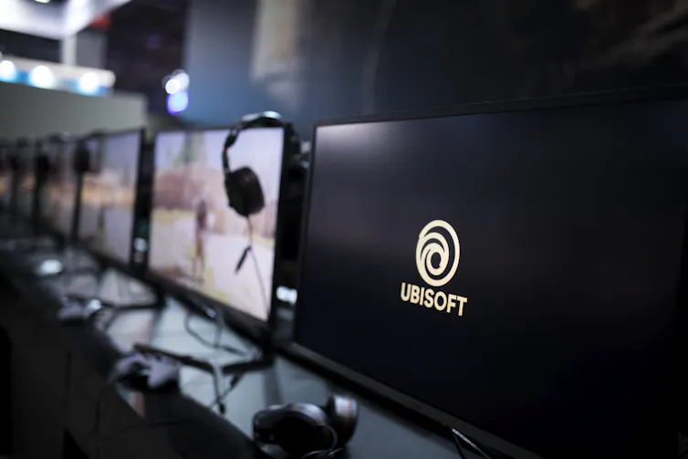 La fila de pantallas de computadora, uno muestra el logotipo de Ubisoft y el nombre de la empresa