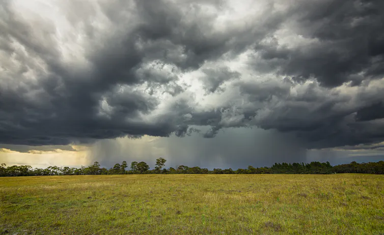 Thunderclouds form over rural setting.