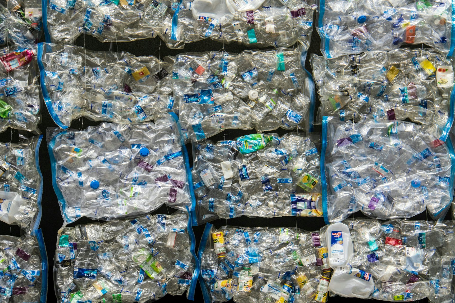 Large, stacked bundles of compressed plastic bottles and containers