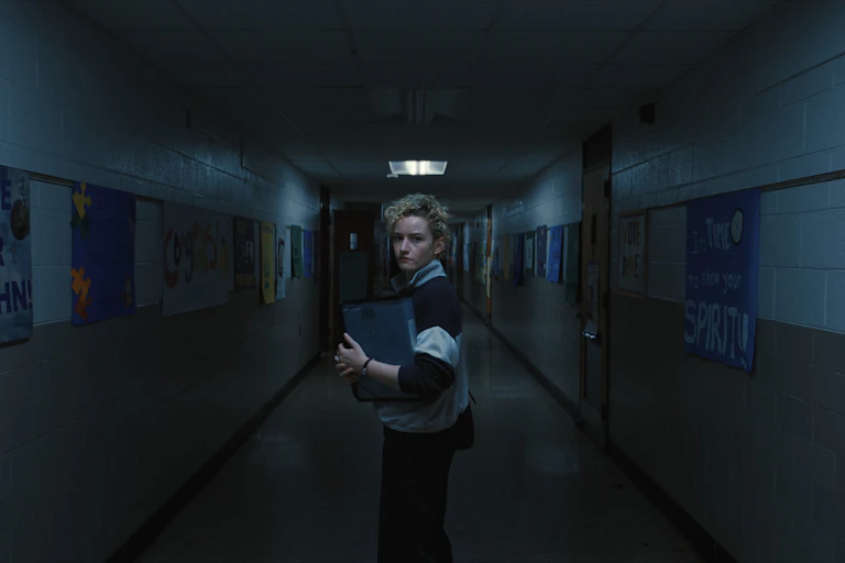 Julia Garner in a dark school hallway