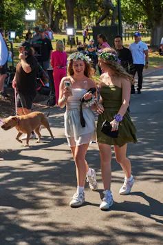 Dos chicas con vestidos ligeros y coronas de flores.