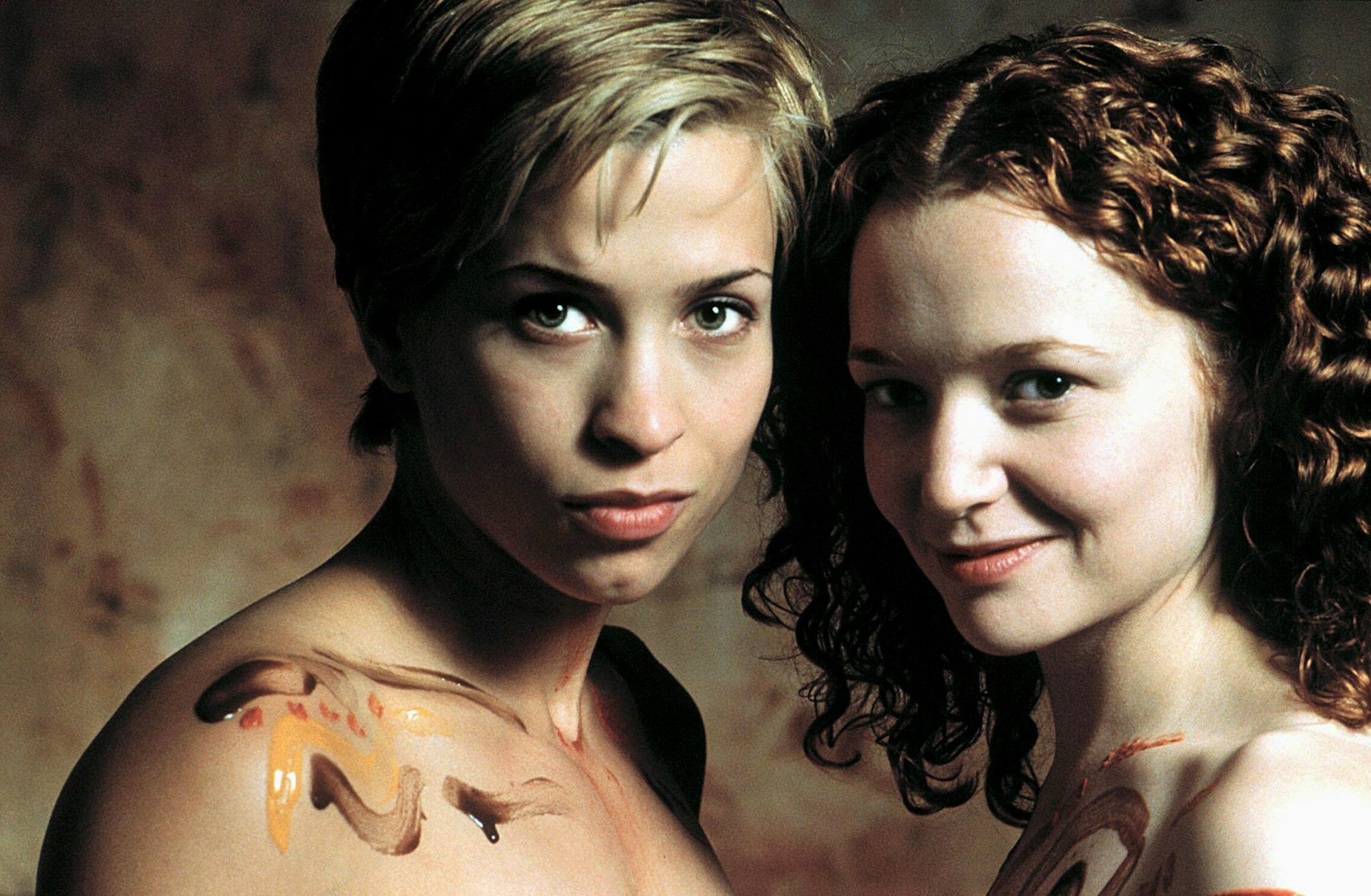 Two women, one with chocolate on her shoulders.