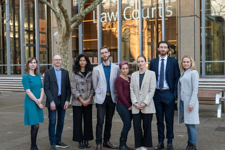 Eight people standing outside a courthouse