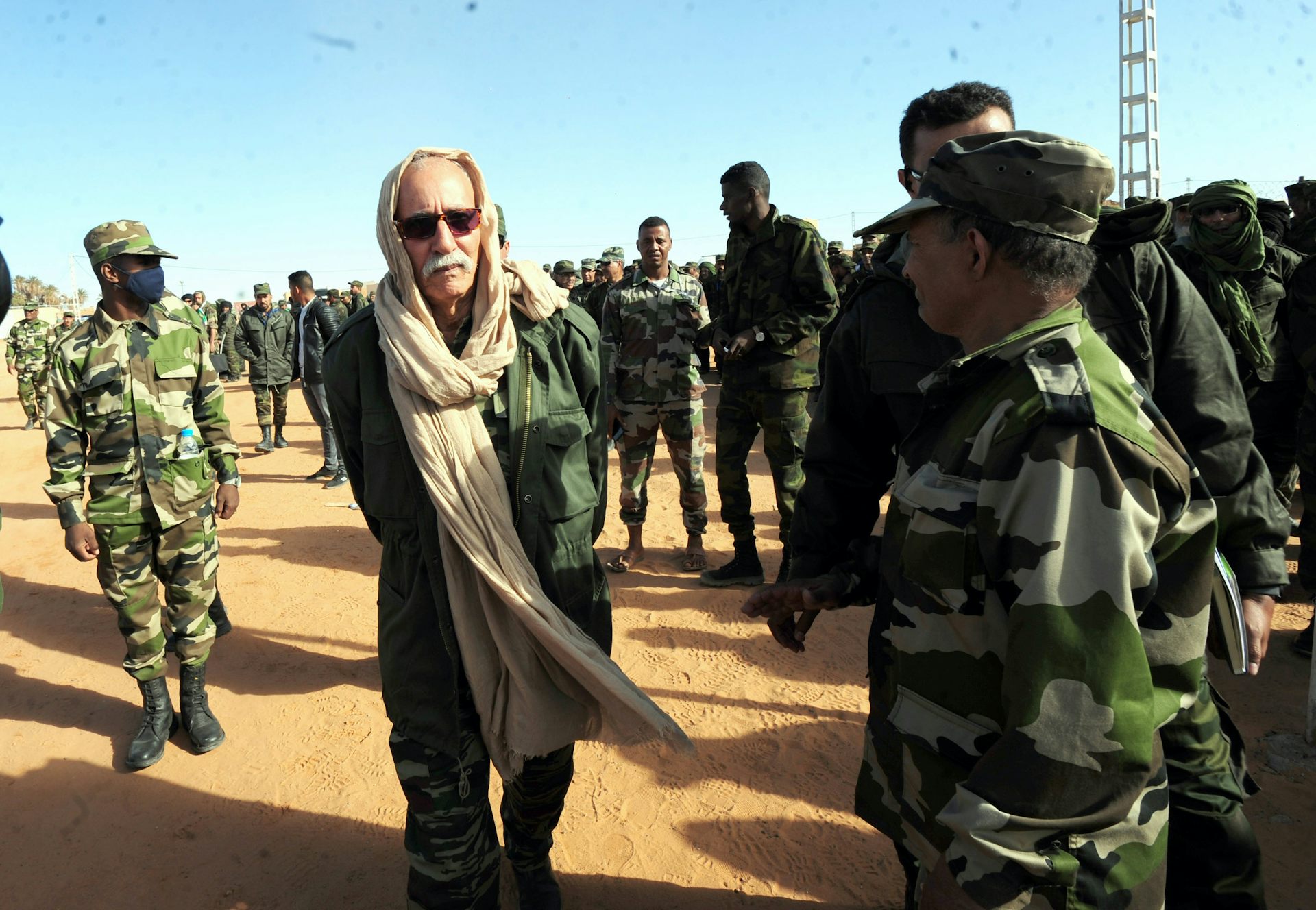 Brahim Ghali surrounded by people in military clothing.