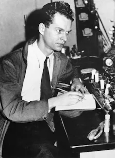 Black and white photo of B.F. Skinner at a lab desk.